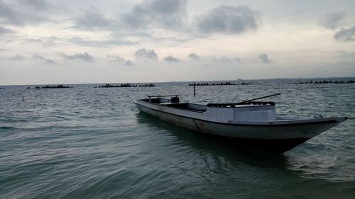 Boat moored in sea against sky