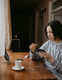 Young woman using mobile phone at home