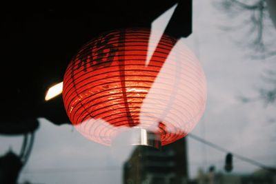 Low angle view of illuminated lantern against indoors