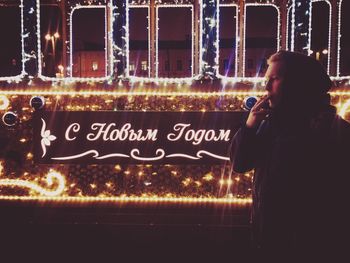 Man photographing illuminated smart phone at night