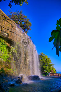 Scenic view of waterfall against sky