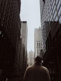 Low angle view of man in city against sky
