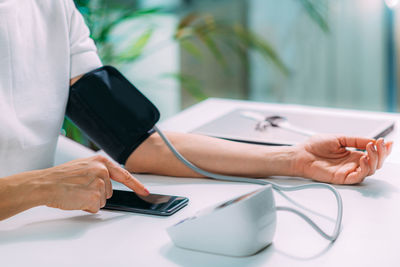 Measuring blood pressure, using smartphone to follow results