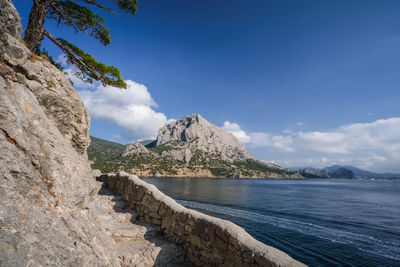 Scenic view of sea and mountains against sky