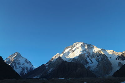 Scenic view of snowcapped mountains against clear blue sky