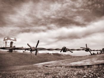 Close-up of barbed wire against sky