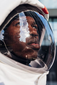 Male astronaut wearing space helmet looking up