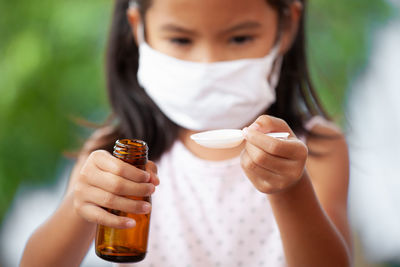 Close-up of girl taking syrup in spoon