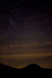 Low angle view of silhouette landscape against sky at night