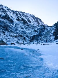 Scenic view of snowcapped mountains by sea during winter