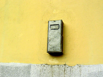 Close-up of window on yellow wall