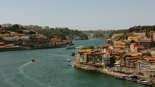 High angle view of sea amidst townscape against clear sky