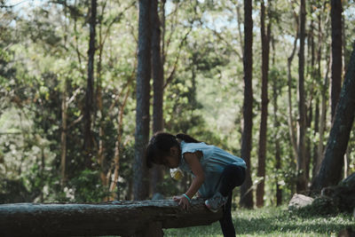 Side view of girl playing at forest