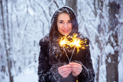 Portrait of smiling woman standing in snow