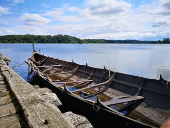 Panoramic view of boats moored at lake against sky