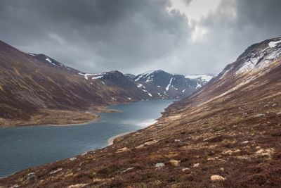 Idyllic shot of loch avon and mountains against cloudy sky