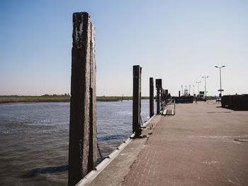 Pier over river against clear sky