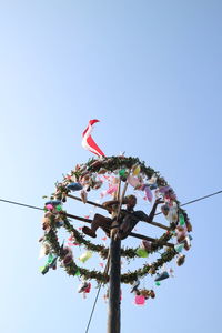 Low angle view of chain swing ride against clear sky