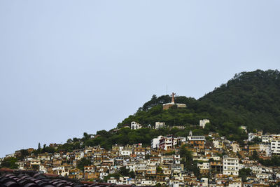 Buildings in town against clear sky