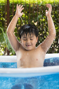 Portrait of a boy playing in the inflatable pool at his home. cool summer activities. 