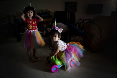 Cute girls wearing unicorn costumes at home