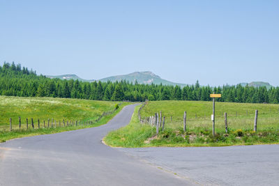 Road amidst green landscape against clear sky