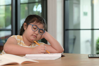 Asian girls are tutoring at home, study online at home, girls are bored and tired from studying.