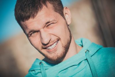 Close-up portrait of smiling young adult man