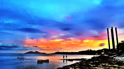 Scenic view of sea against dramatic sky during sunset