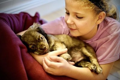 Young girl embracing a cute puppy.