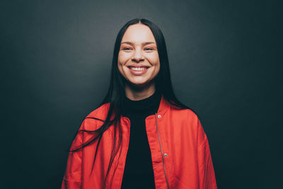 Young woman smiling over gray background