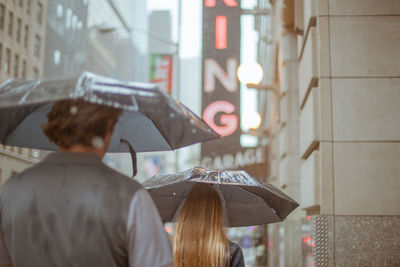 Rear view of people with umbrellas on road