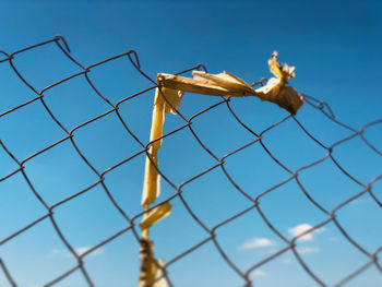 Low angle view of chainlink fence against sky