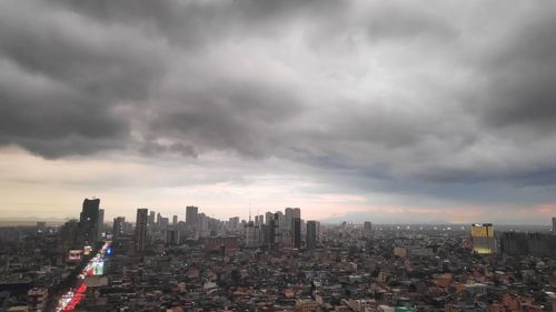 Aerial view of buildings in city against sky