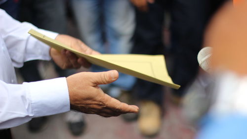 Midsection of man holding book