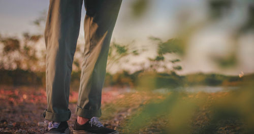 Low section of man standing on field