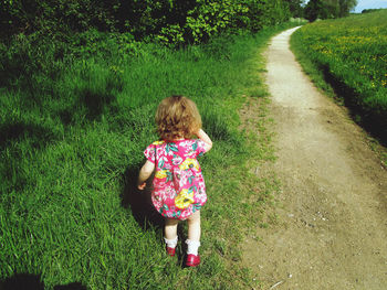 Rear view of toddler  on field