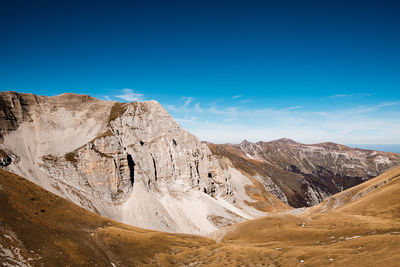 Scenic view of mountains against blue sky in arquata del tronto, marche italy