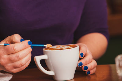 Close-up of hand holding coffee cup