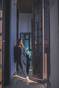 Rear view of woman standing in abandoned building