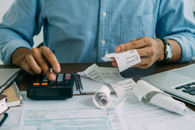 Midsection of accountant working on table