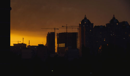 Silhouette buildings against sky during sunset