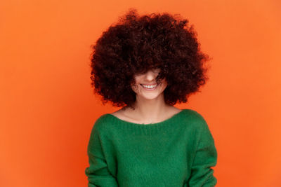 Portrait of young woman against yellow background