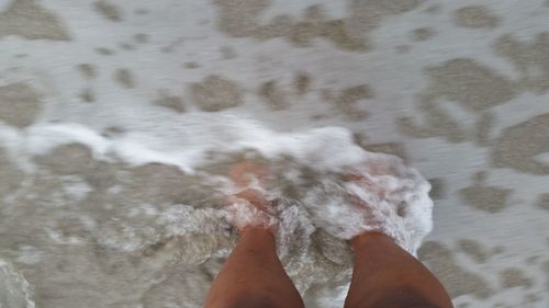 Low section of person on sand at beach