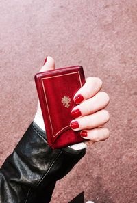 Cropped hand of woman holding red purse