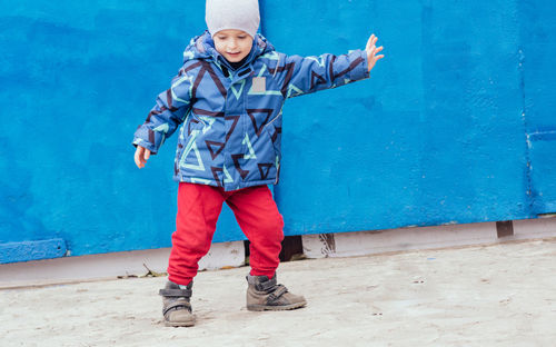 A cheerful child outdoors expresses himself through movement. power, joyful, rhythm, emotion. 