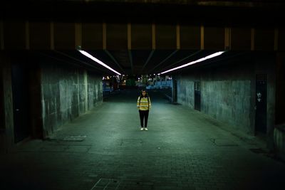 Woman in illuminated underground walkway