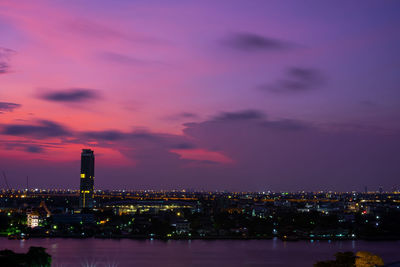 Illuminated buildings against sky at sunset