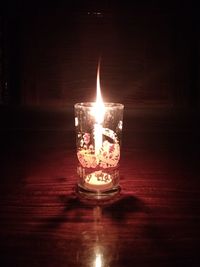 Close-up of lit candle in the dark