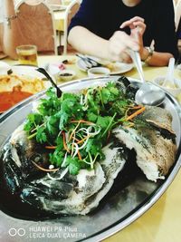 Close-up of seafood served with cilantro in plate on table